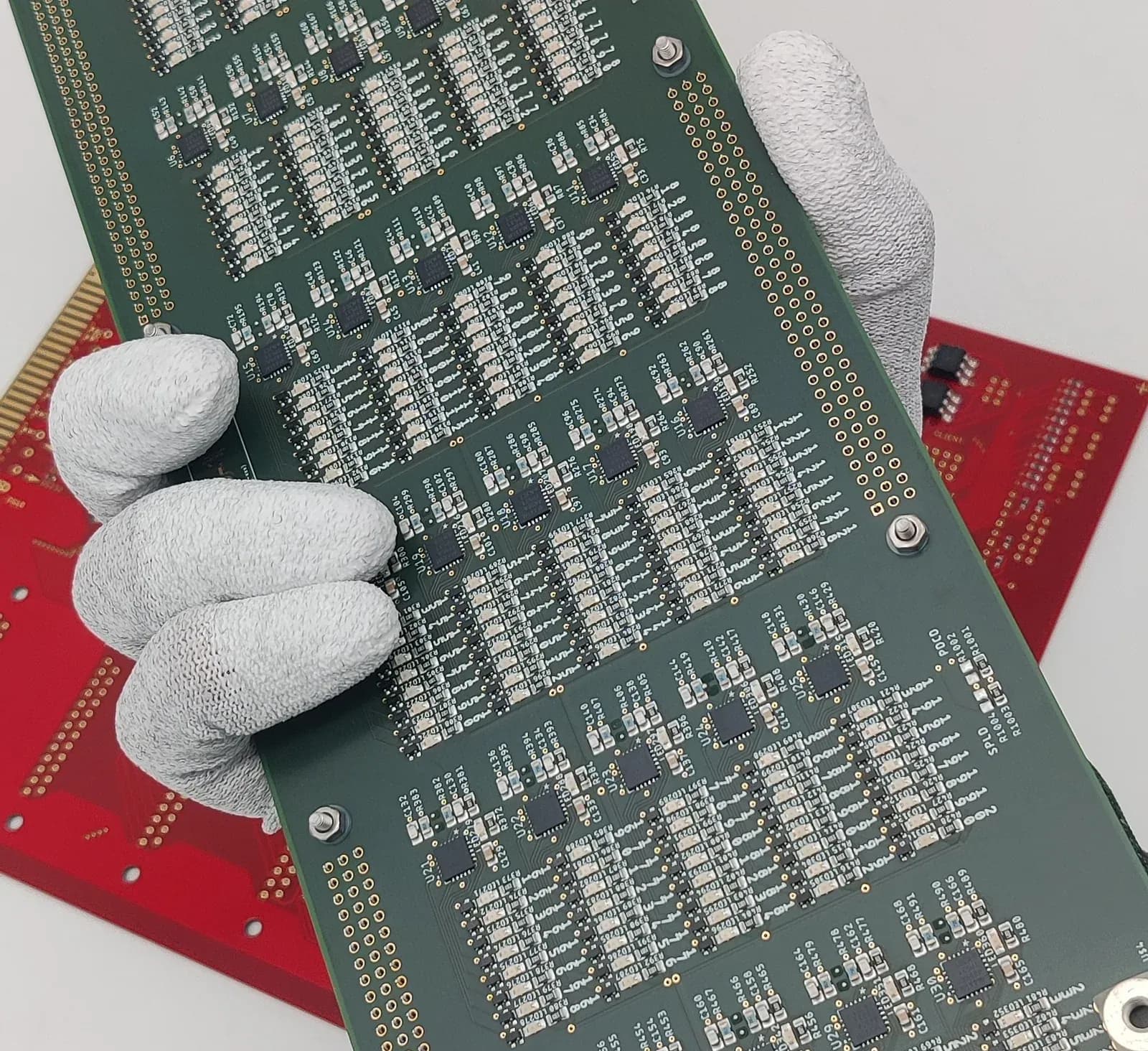 Assembled circuit board held in cleanroom gloves