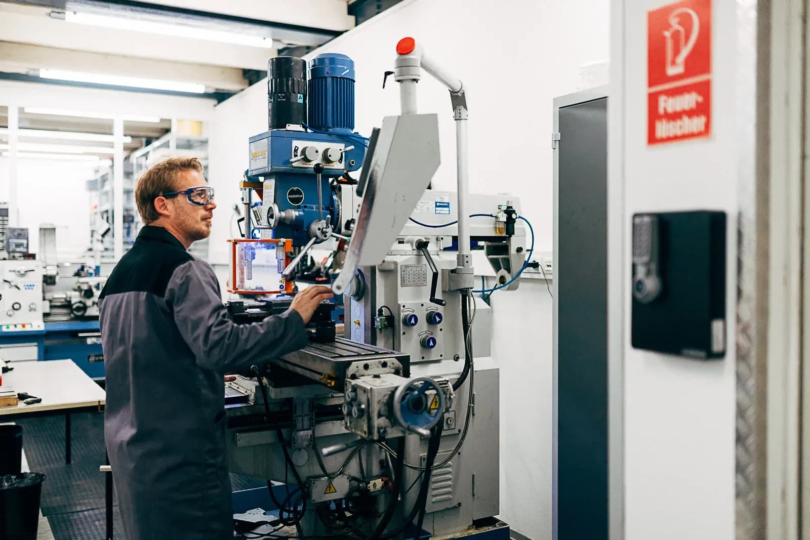 View into the production hall: machinist at a milling machine